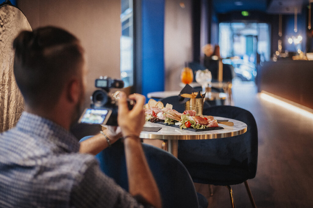 Fotografo professionista che cattura un piatto gourmet in un ristorante elegante, concetto di food photography