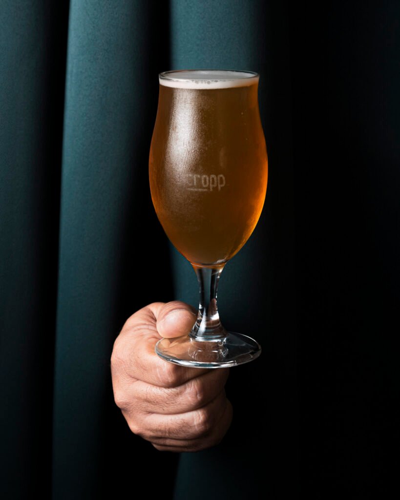 Calice di birra artigianale ambrata tenuto in mano – still life VA Photo