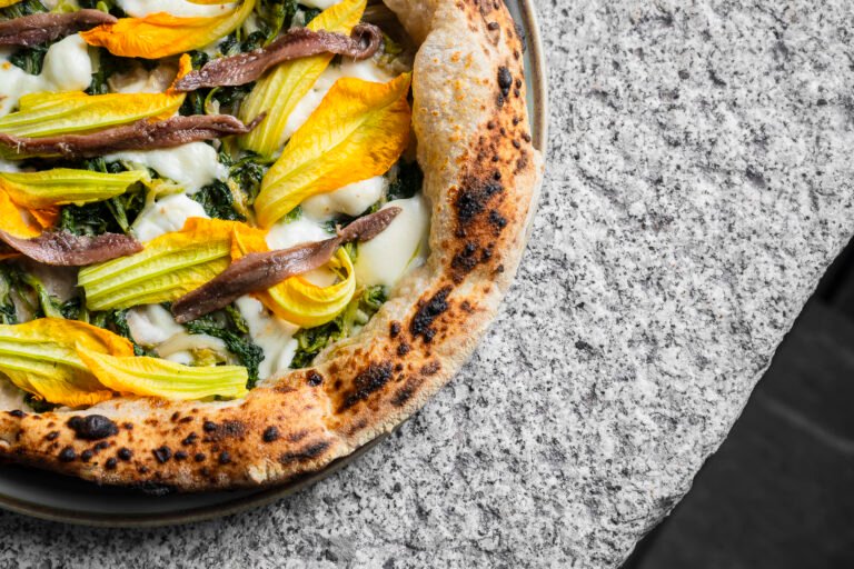 Pizza gourmet con fiori di zucca, alici e mozzarella – fotografia food VA Photo