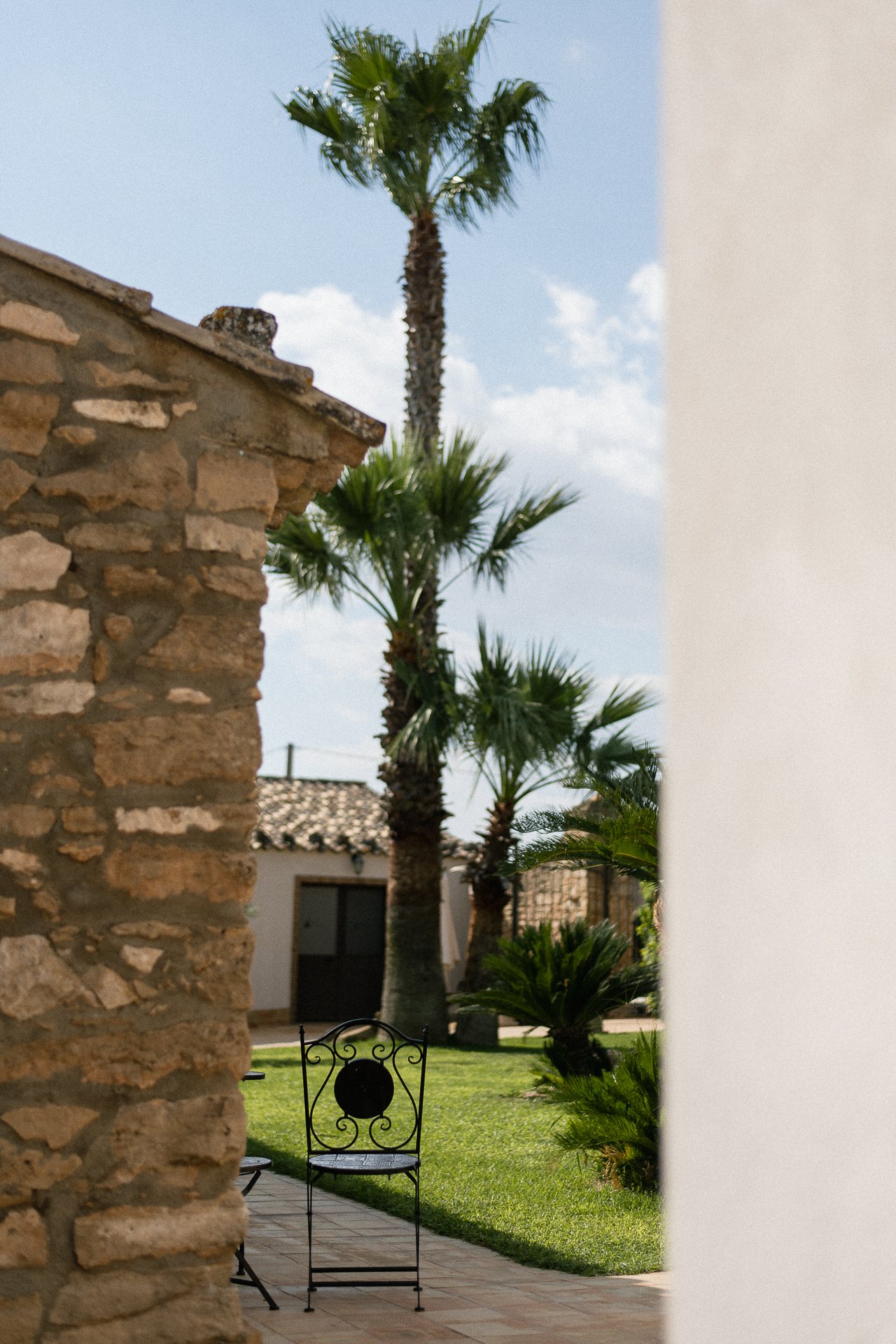 Cortile di un agriturismo in Sicilia con palme e pietra a vista - fotografia food e location di Andrea Ventura