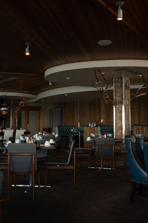 Interno di un ristorante elegante con soffitto in legno e illuminazione calda