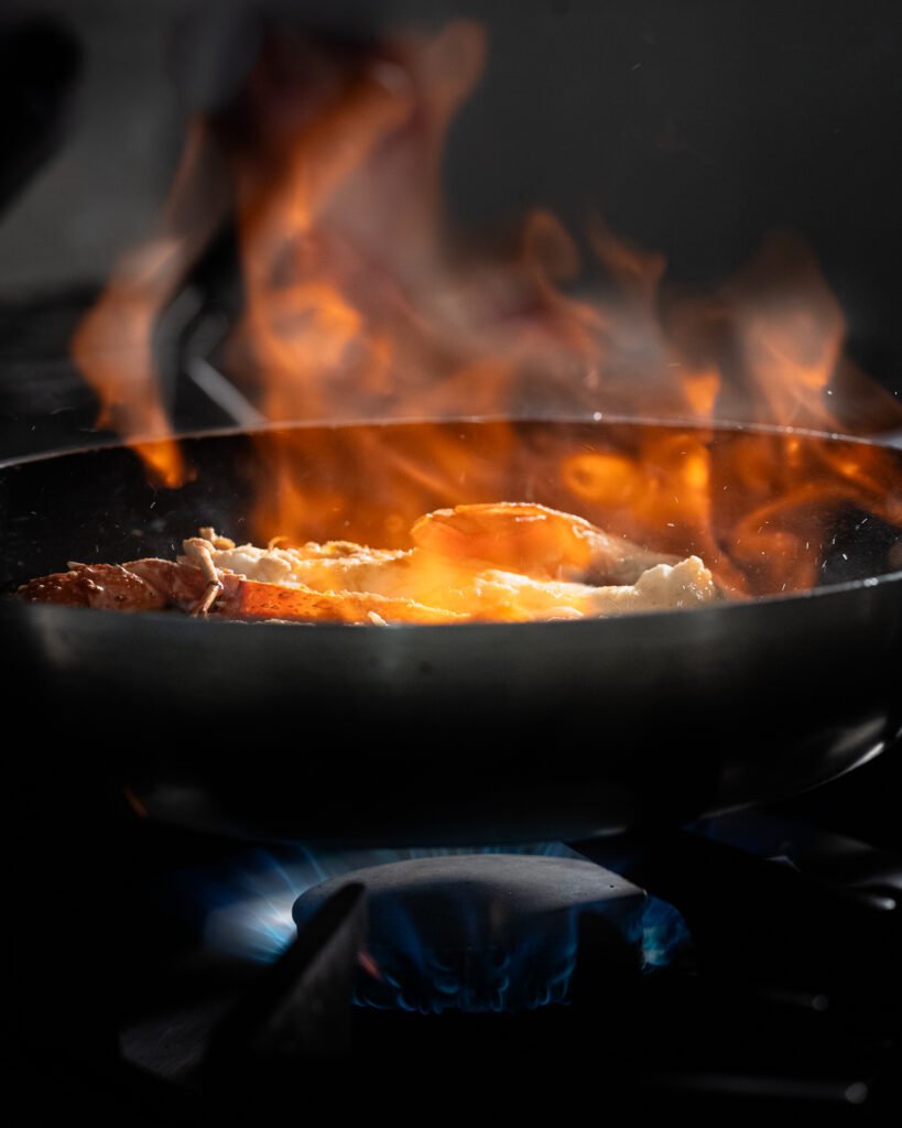 Fiammata in padella sul fornello durante la cottura, fotografia in cucina in Sicilia