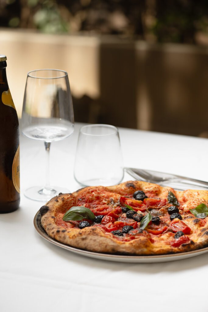 Pizza servita su tavola apparecchiata in un ristorante siciliano
