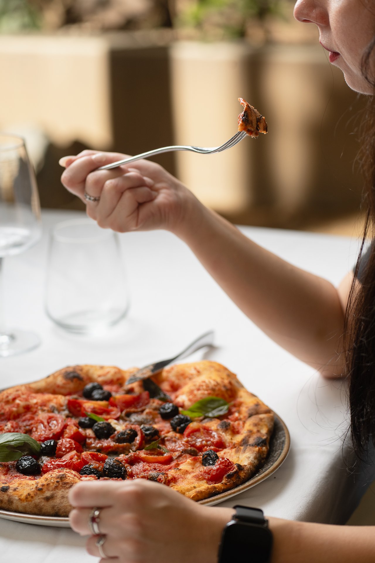 Cliente che mangia una pizza all'aperto in un ristorante siciliano, fotografia di Andrea Ventura