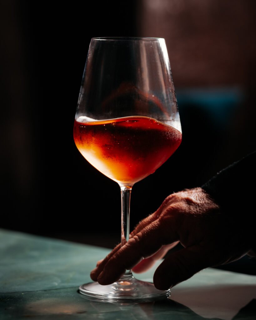 Calice di vino su tavolo in marmo verde con luce laterale, fotografia di Andrea Ventura