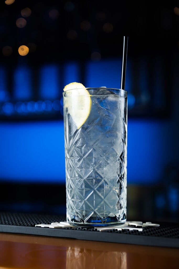 Drink trasparente con ghiaccio e limone in un bicchiere di cristallo al bancone, fotografia di Andrea Ventura per Habanero